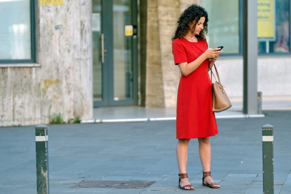 Persoon die op de bank naar zijn smartphone kijkt met een serieuze blik