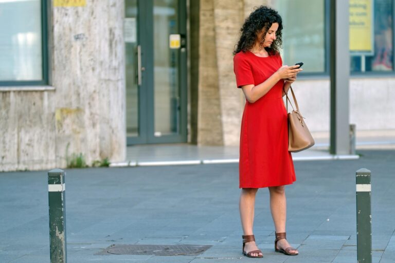 Persoon die op de bank naar zijn smartphone kijkt met een serieuze blik